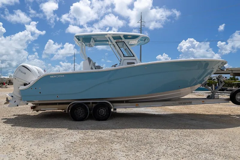 Slide: The Image of 2026 Sea Fox 288 Commander boat on trailer under a clear blue sky. - 5