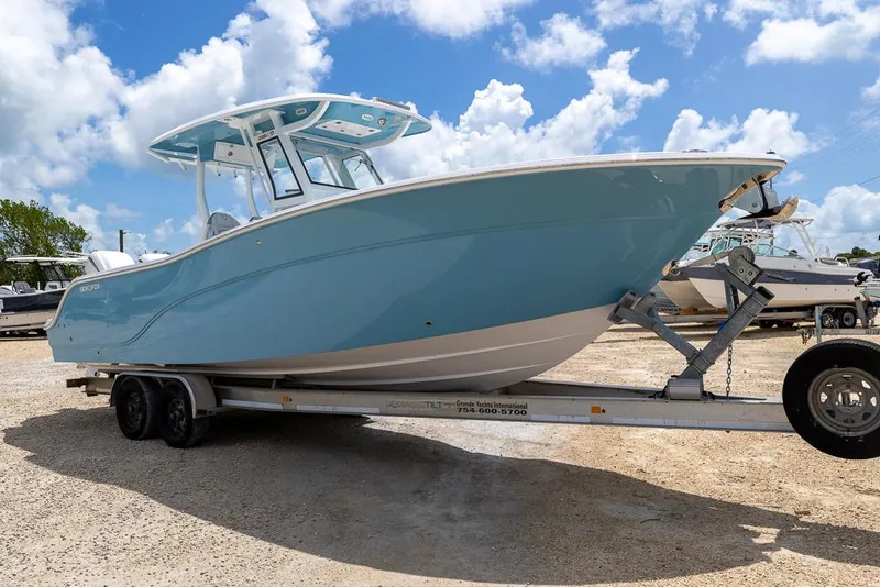 Slide: The Image of 2026 Sea Fox 288 Commander boat on trailer under a bright blue sky. - 6