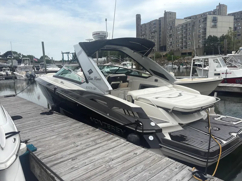 Slide: The Image of 2014 Monterey 328 Super Sport boat docked at a marina with cityscape background. - 10
