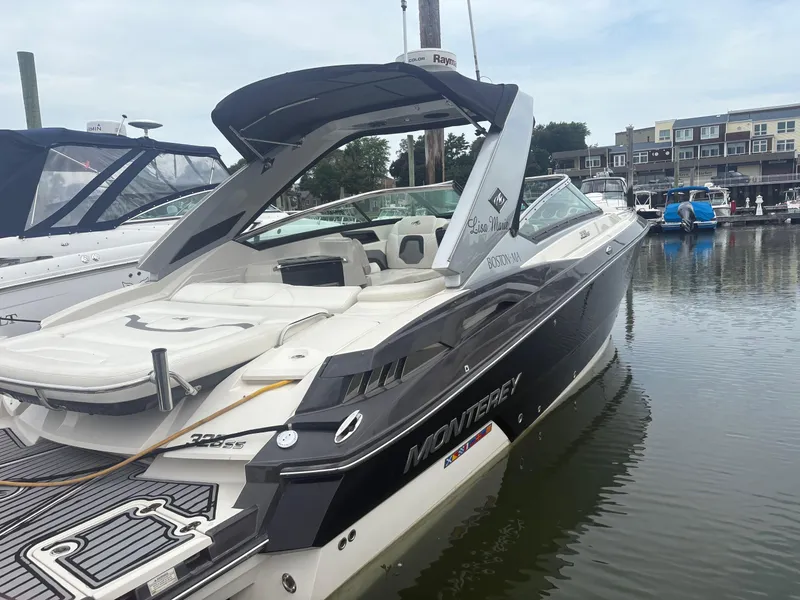 Slide: The Image of 2014 Monterey 328 Super Sport boat docked in marina, featuring sleek design and spacious seating. - 11