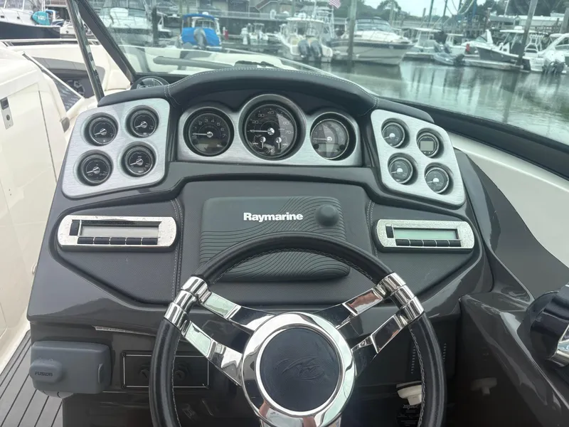 Slide: The Image of Dashboard of a 2014 Monterey 328 Super Sport boat with Raymarine equipment. - 14