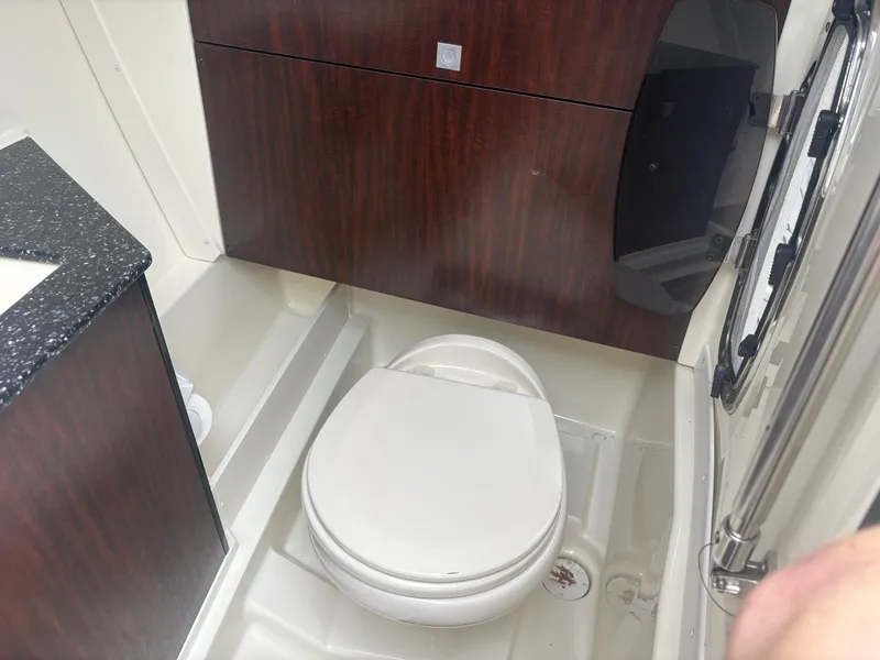 Slide: The Image of 2014 Monterey 328 Super Sport boat bathroom with toilet and wood paneling. - 18
