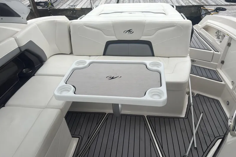 Slide: The Image of 2014 Monterey 328 Super Sport boat interior with white seating and table. - 24