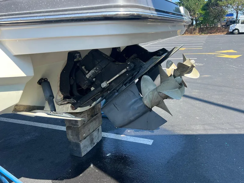 Slide: The Image of 2014 Monterey 328 Super Sport boat propeller and stern drive on blocks in parking lot. - 28