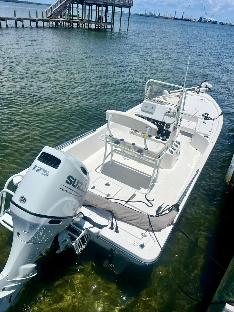 Slide: The Image of 2021 Blazer Bay 2200 boat with Suzuki 175 engine docked in clear water. - 10