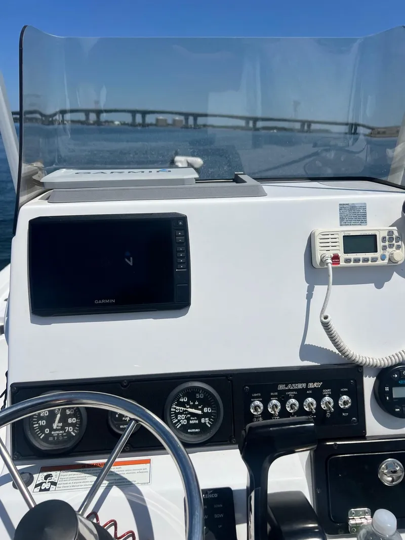 Slide: The Image of 2021 Blazer Bay 2200 boat dashboard with steering wheel, gauges, and navigation equipment. - 12