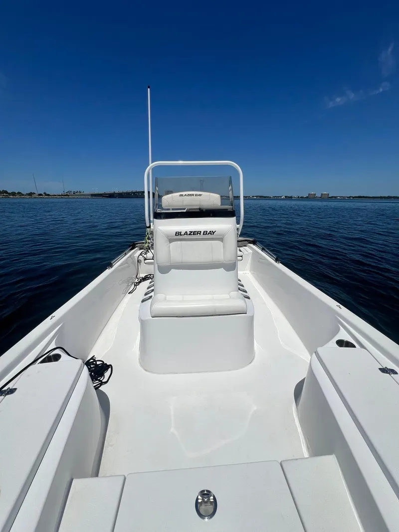 Slide: The Image of 2021 Blazer Bay 2200 boat on calm water under clear blue sky. - 14