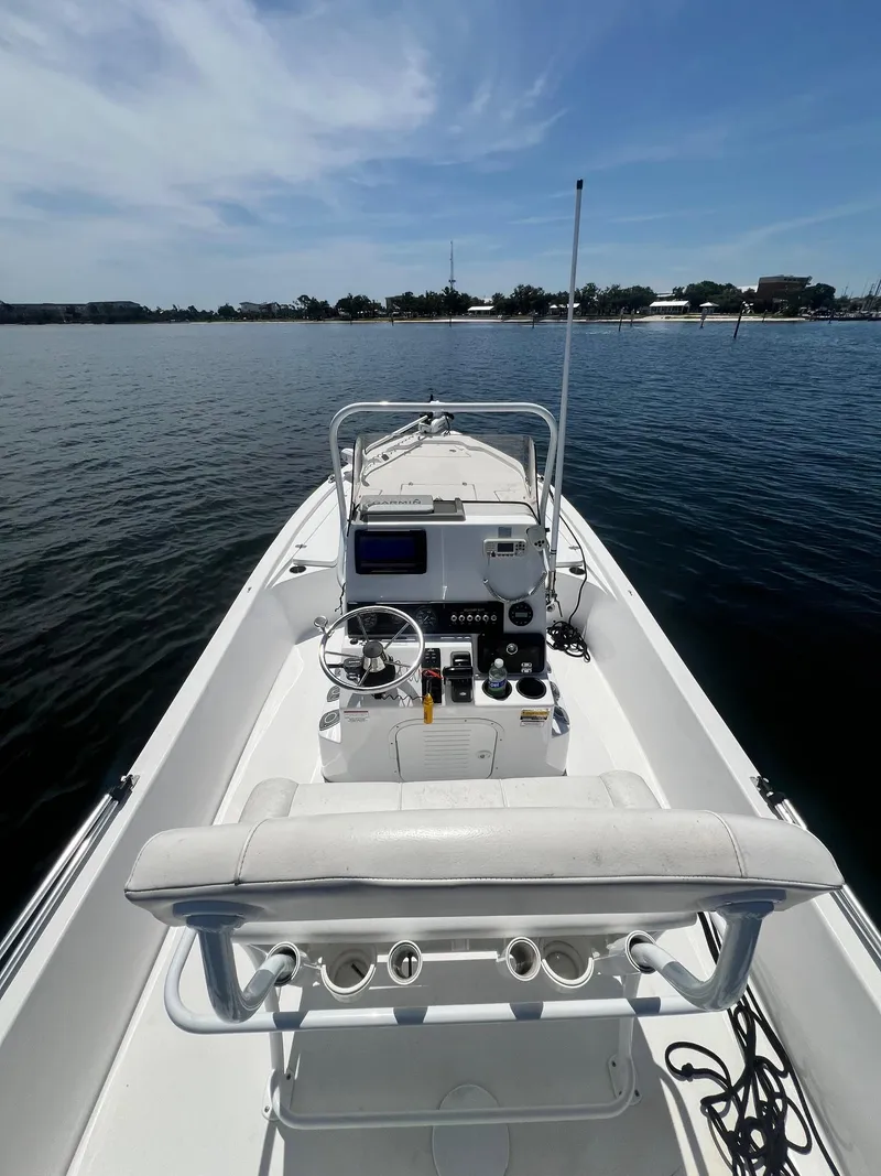 Slide: The Image of 2021 Blazer Bay 2200 boat on calm water, featuring a sleek console and steering wheel. - 16