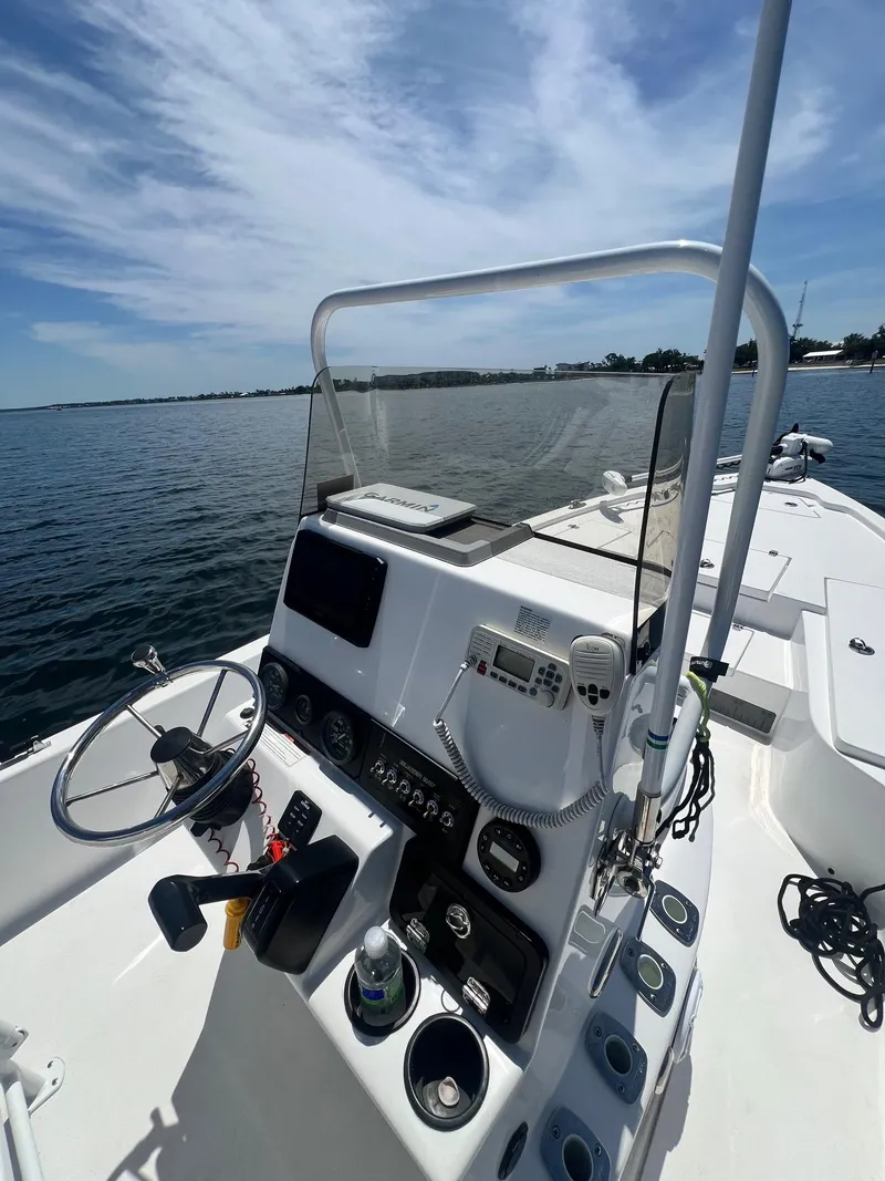 Slide: The Image of 2021 Blazer Bay 2200 boat console with steering wheel and controls on open water. - 17