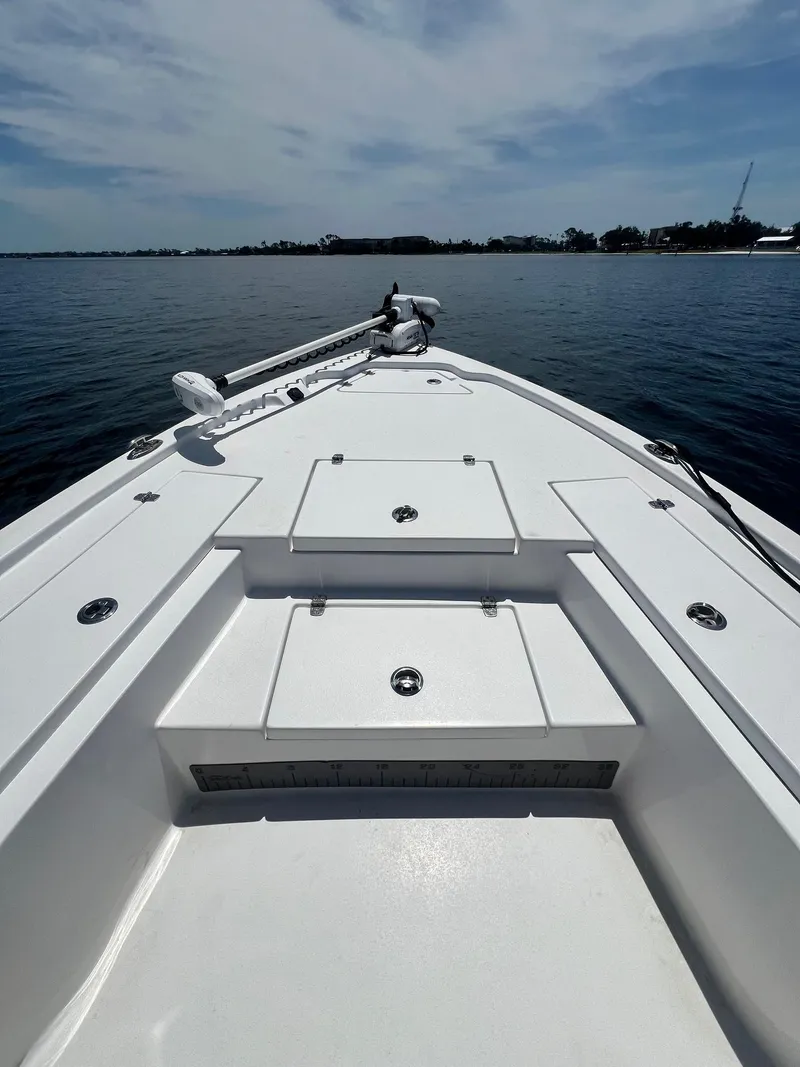 Slide: The Image of 2021 Blazer Bay 2200 boat deck on calm water under a partly cloudy sky. - 6