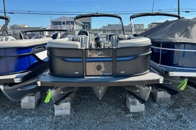 Slide: The Image of 2026 Barletta C24M pontoon boat displayed on blocks in a marina setting. - 3