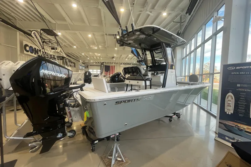 Slide: The Image of 2025 Sportsman Masters 227 Bay Boat displayed indoors with Mercury engine. - 0