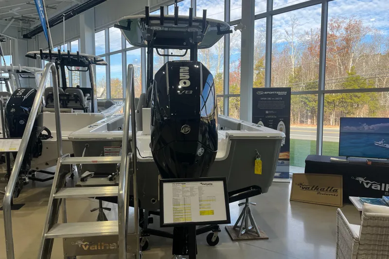 Slide: The Image of 2025 Sportsman Masters 227 Bay Boat displayed in showroom with powerful outboard motor. - 1