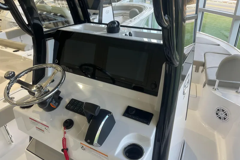 Slide: The Image of 2025 Sportsman Masters 227 Bay Boat helm with steering wheel and control panel. - 2