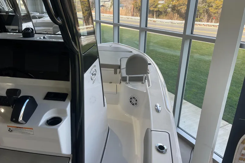 Slide: The Image of 2025 Sportsman Masters 227 Bay Boat interior, showcasing helm and seating, in showroom setting. - 5