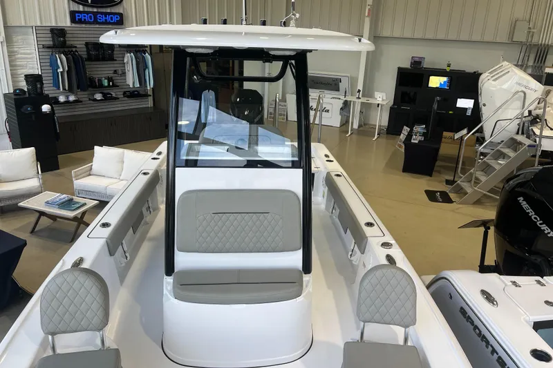 Slide: The Image of 2025 Sportsman Masters 227 Bay Boat displayed in a showroom with modern seating and equipment. - 6
