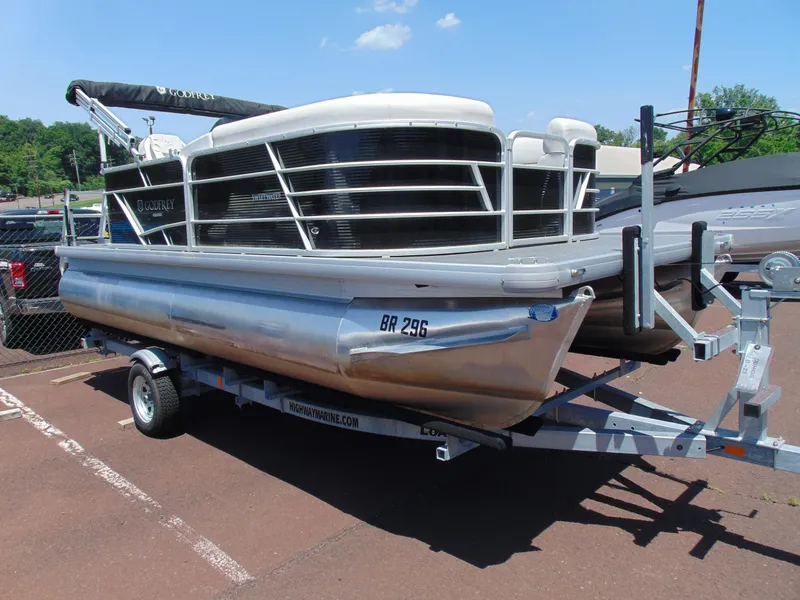 The Image of 2022 Godfrey Sweetwater 1880 CX pontoon boat on trailer, parked outdoors. - 1