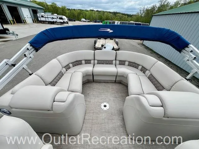 Slide: The Image of 2017 Bennington R23 pontoon boat with spacious seating and blue canopy, parked outdoors. - 16