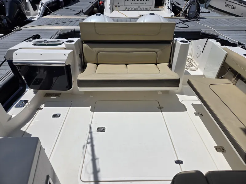 Slide: The Image of 2020 Pursuit DC 326 Dual Console boat interior with beige seating and spacious deck. - 16