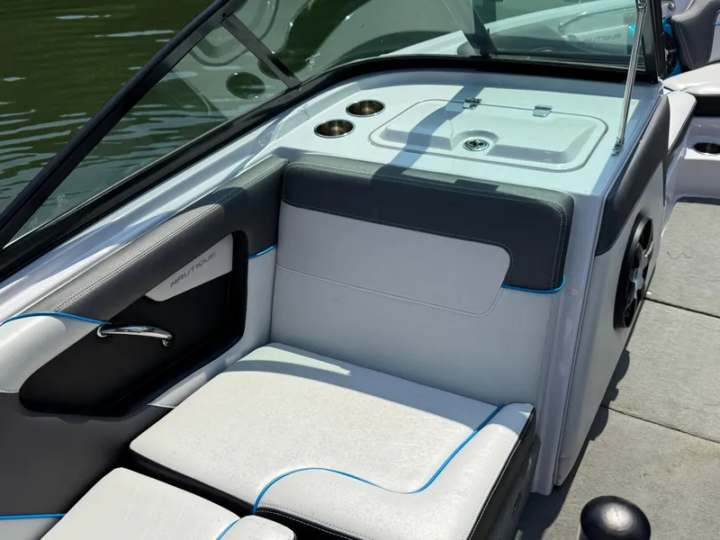 Slide: The Image of 2014 Nautique Sport 200 boat interior with white and black seating, cup holders, and speaker. - 12