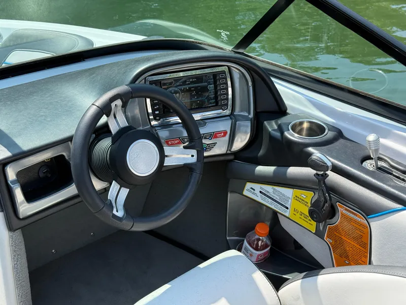 Slide: The Image of 2014 Nautique Sport 200 boat dashboard with steering wheel and control panel. - 14
