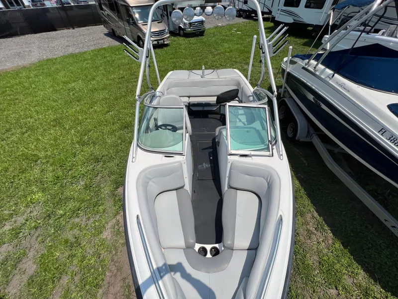 Slide: The Image of 2004 MasterCraft MariStar 210 VRS boat with open bow seating, parked on grass. - 18
