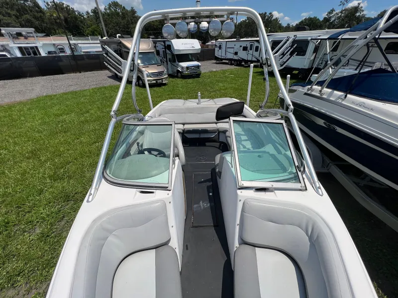 Slide: The Image of 2004 MasterCraft MariStar 210 VRS boat with open seating and tower, parked outdoors. - 19