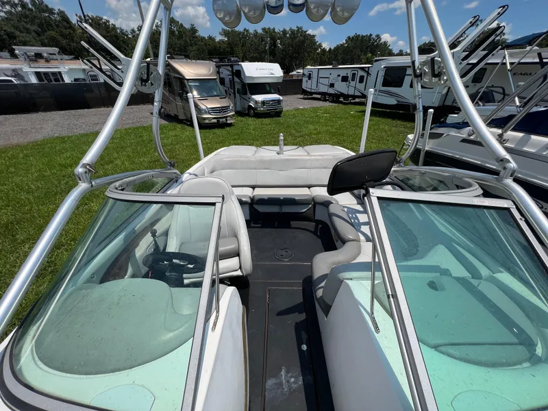 Slide: The Image of 2004 MasterCraft MariStar 210 VRS boat interior with seating and windshield, parked near RVs. - 21