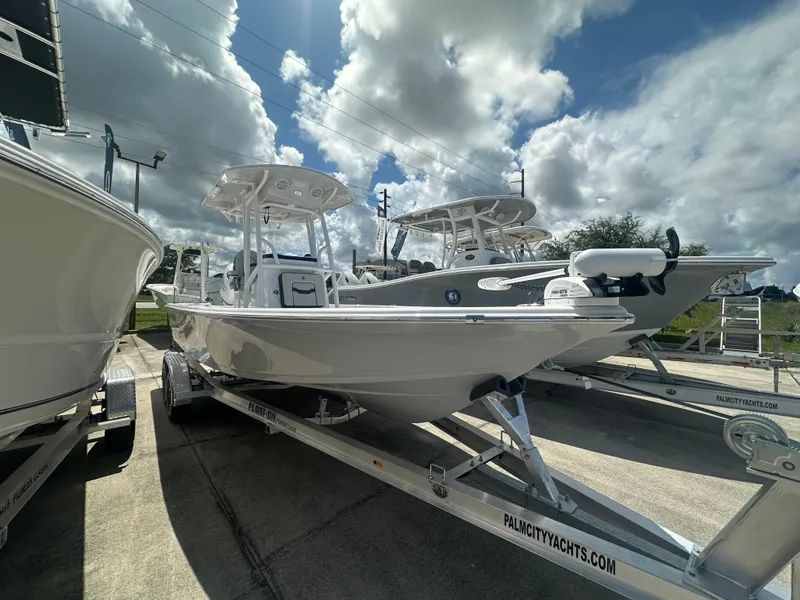 The Image of 2025 Sea Pro 230 Bay boat on trailer under cloudy sky at dealership. - 1