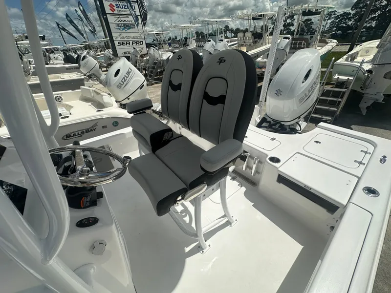 Slide: The Image of 2025 Sea Pro 230 Bay boat interior with dual seats and Suzuki outboard motor. - 11