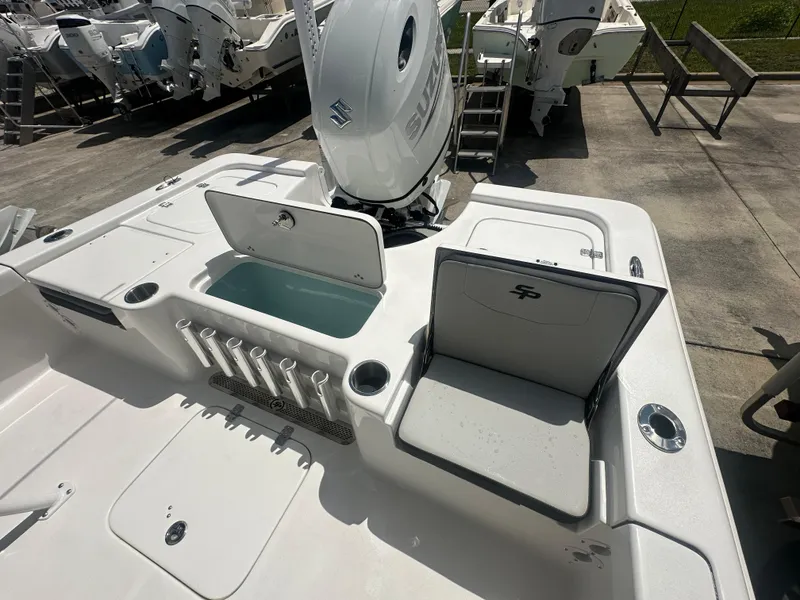 Slide: The Image of 2025 Sea Pro 230 Bay boat deck with storage compartments and rod holders. - 12