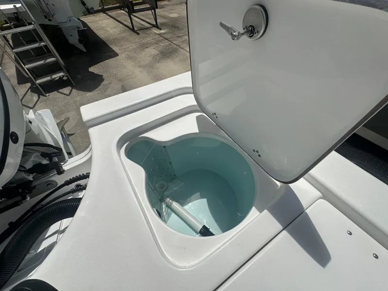 Slide: The Image of Livewell compartment on a 2025 Sea Pro 230 Bay boat, open lid, showing interior. - 13