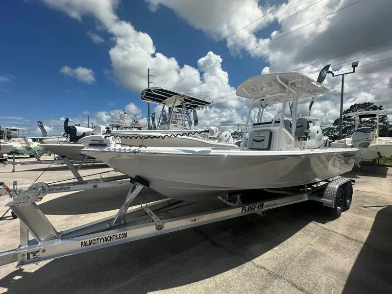 Slide: The Image of 2025 Sea Pro 230 Bay boat on trailer under a clear blue sky. - 2