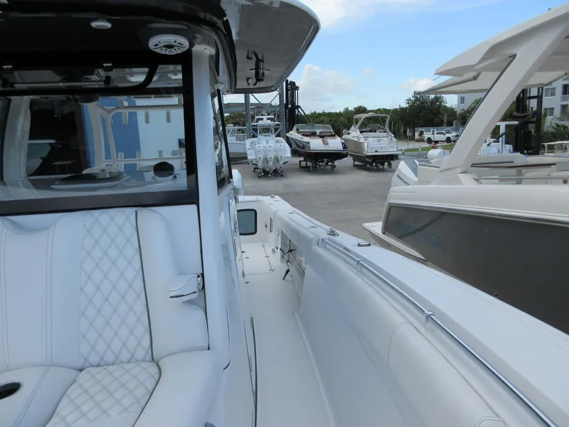 Slide: The Image of 2021 Sportsman Open 352 Center Console boat at marina, surrounded by other vessels. - 22