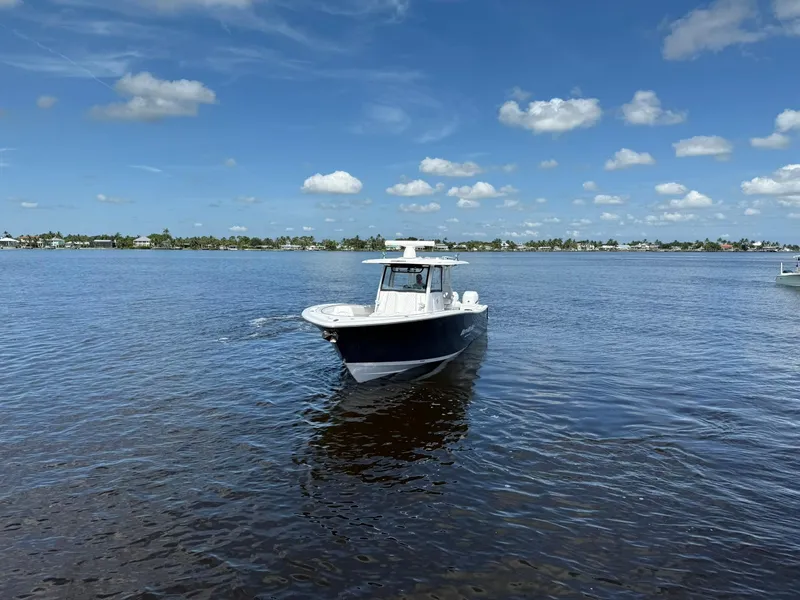 Slide: The Image of 2021 Sportsman Open 352 Center Console boat on calm water under blue sky. - 6