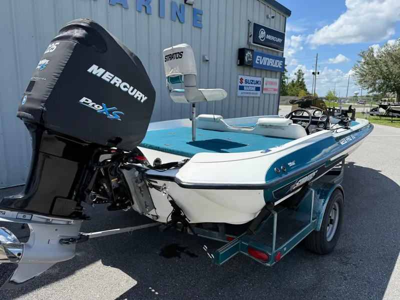 Slide: The Image of 1995 Stratos 201XL boat with Mercury Pro XS engine, parked outside a marine dealership. - 12