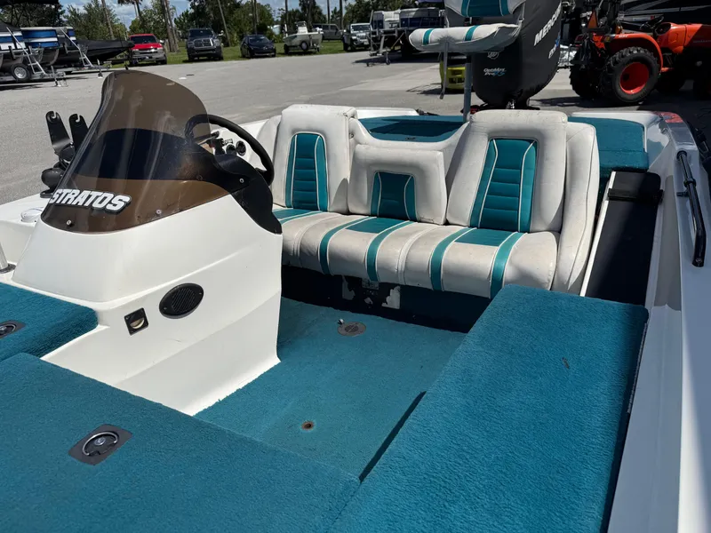 Slide: The Image of 1995 Stratos 201XL boat interior with teal and white seating, steering console, and windshield. - 7