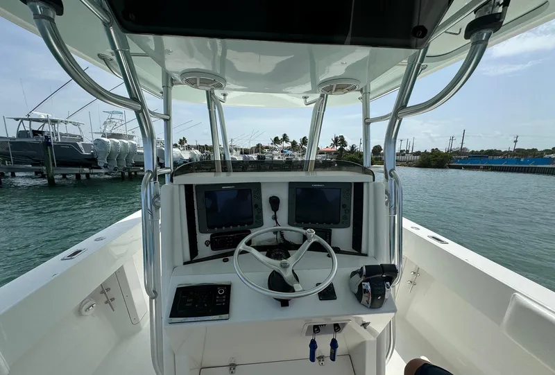 Slide: The Image of 2006 Venture 34 Open boat helm with dual screens and steering wheel on water. - 16