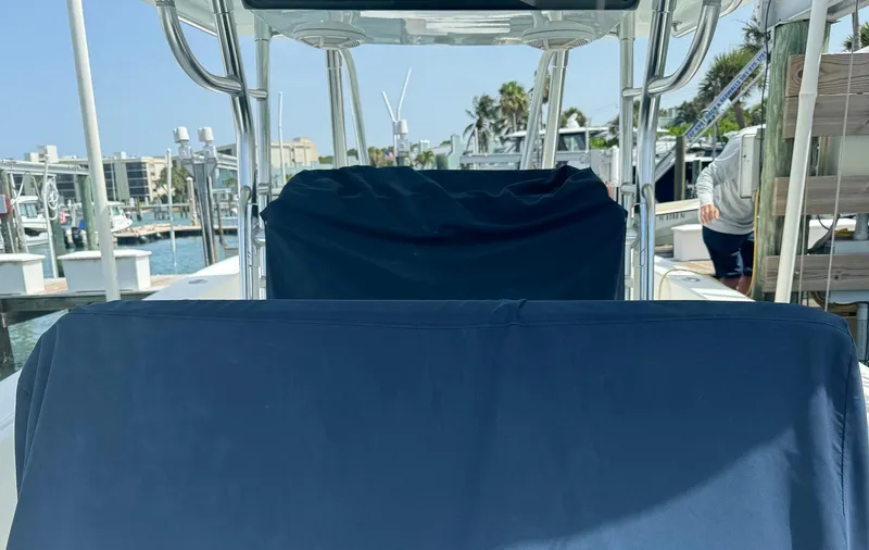 Slide: The Image of 2006 Venture 34 Open boat interior with blue seat covers at a marina. - 26