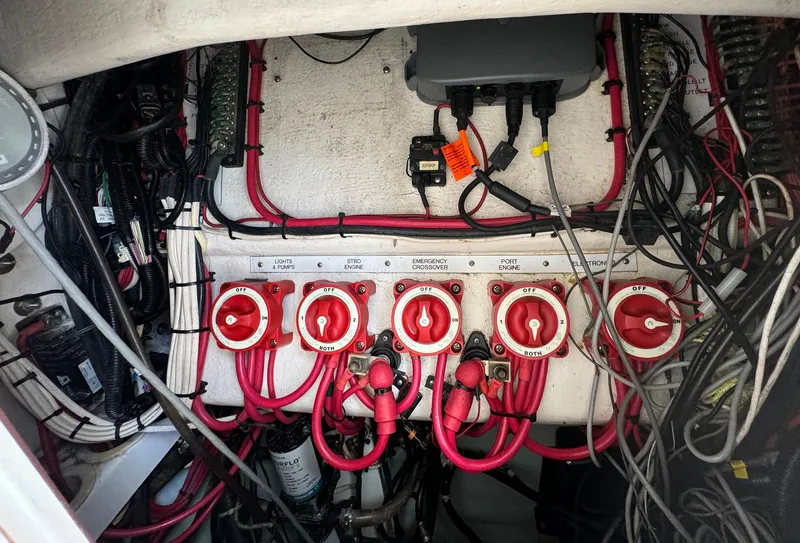 Slide: The Image of Electrical panel of a 2006 Venture 34 Open boat with red switches and wiring. - 28