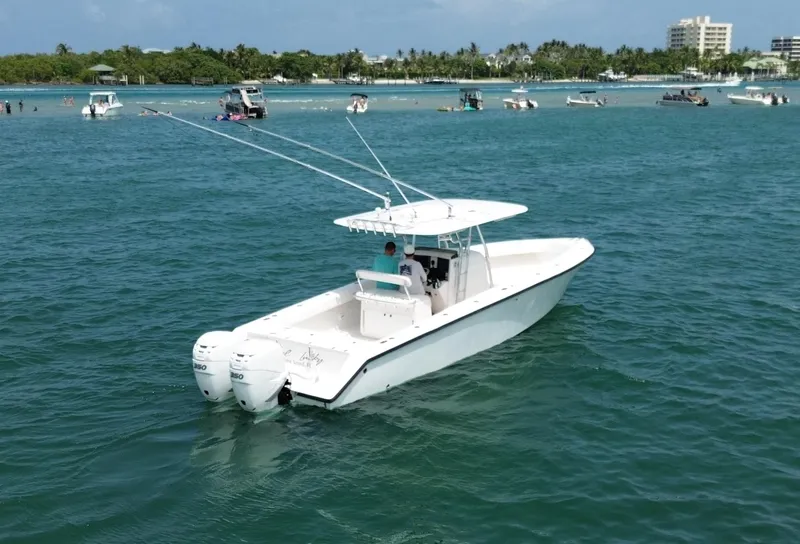 Slide: The Image of 2006 Venture 34 Open boat on calm blue water, with dual engines and fishing rods. - 6