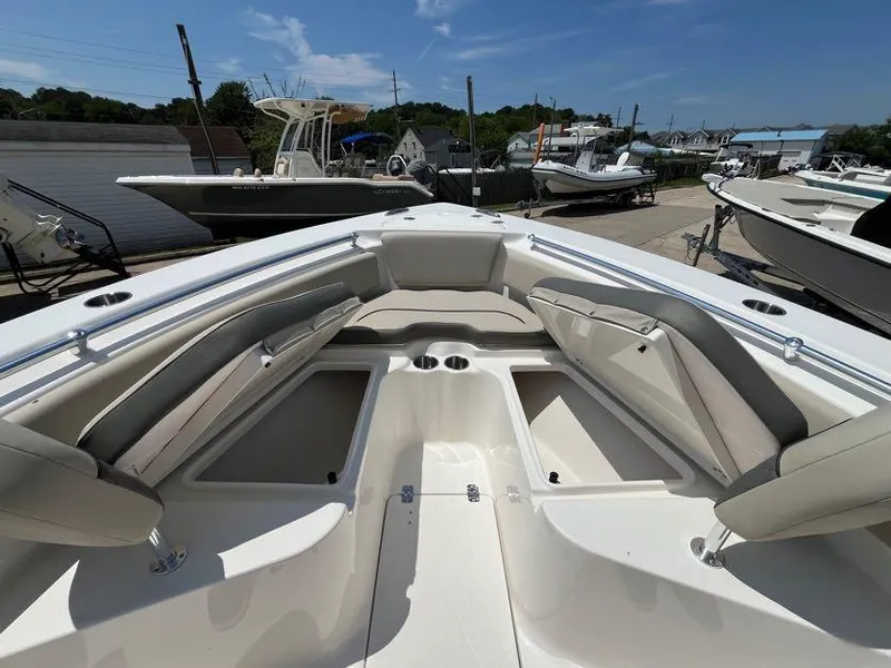 Slide: The Image of 2025 Key West 239 FS boat interior with seating and storage, docked under a clear sky. - 9