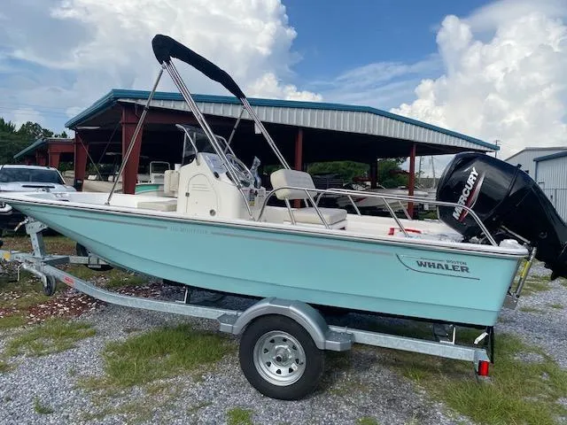 The Image of 2025 Boston Whaler 150 Montauk boat on trailer, parked outdoors under a cloudy sky. - 0