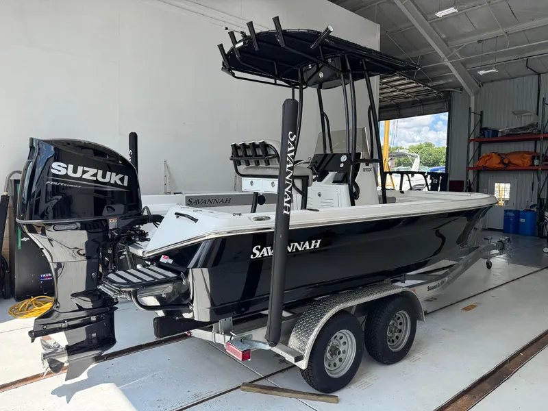 Slide: The Image of 2025 Savannah 210X boat on trailer, parked outdoors under clear sky. - 0