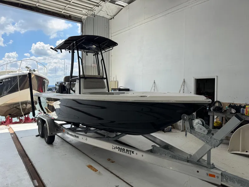 Slide: The Image of 2025 Savannah 210X boat on trailer in parking lot, modern design, black hull. - 1