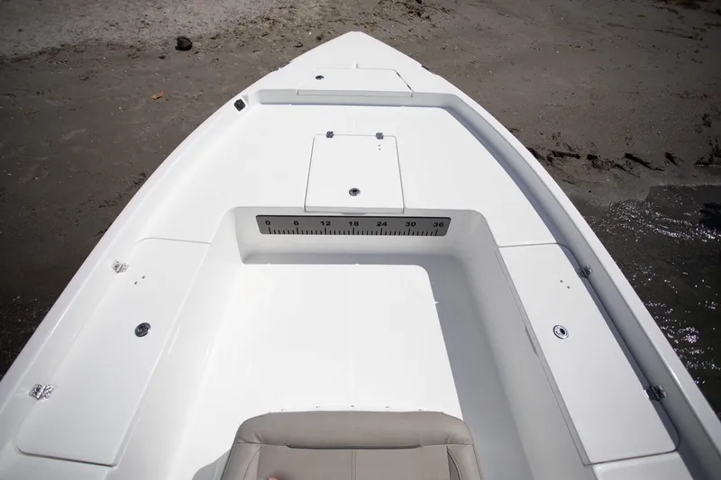 Slide: The Image of Open storage compartment on 2025 Savannah 210X boat deck, featuring a built-in ruler. - 5