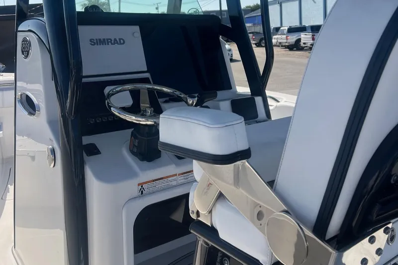 Slide: The Image of 2024 Sea Pro 242 Center Console boat interior with steering wheel and Simrad display. - 4