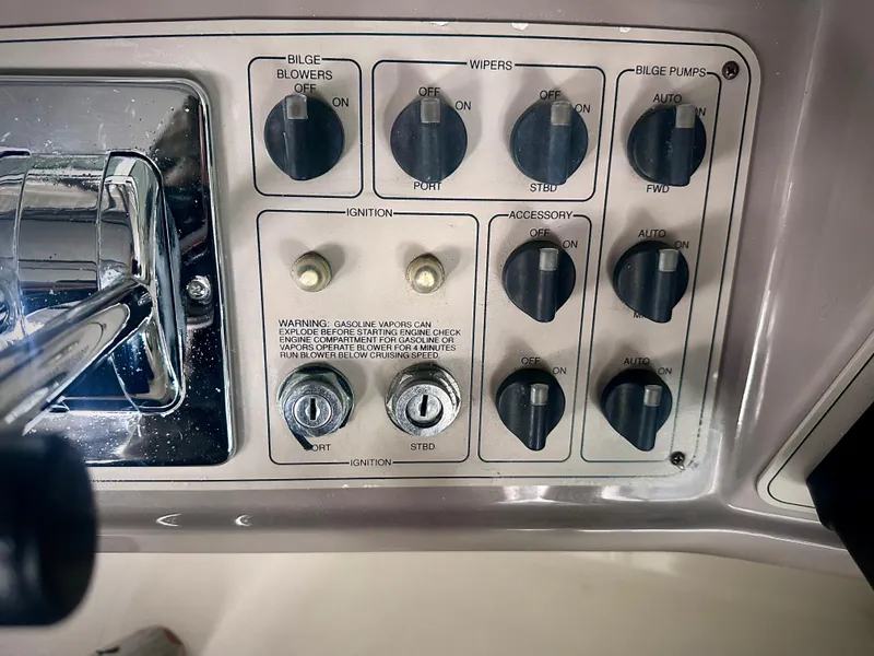 Slide: The Image of Control panel of a 1997 Carver 350 Mariner boat with various switches and ignition. - 12