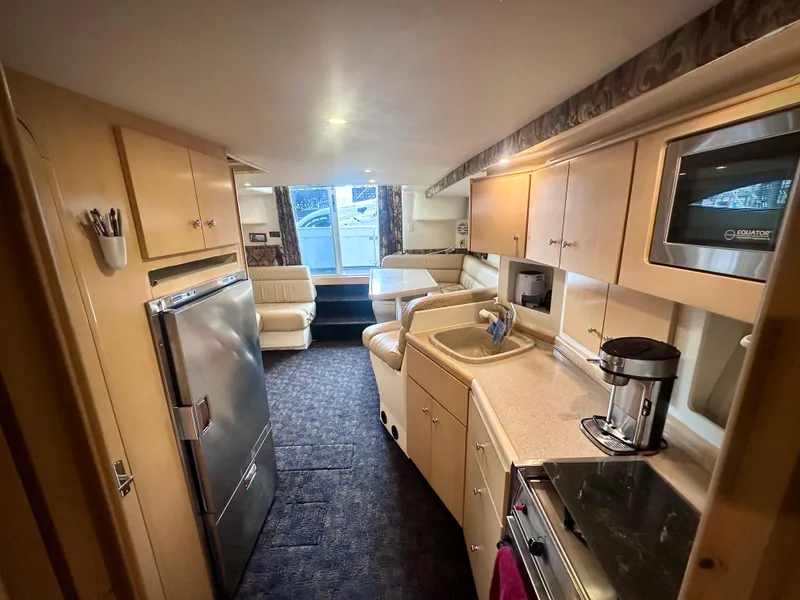 Slide: The Image of Interior of 1997 Carver 350 Mariner yacht with kitchen and seating area. - 26
