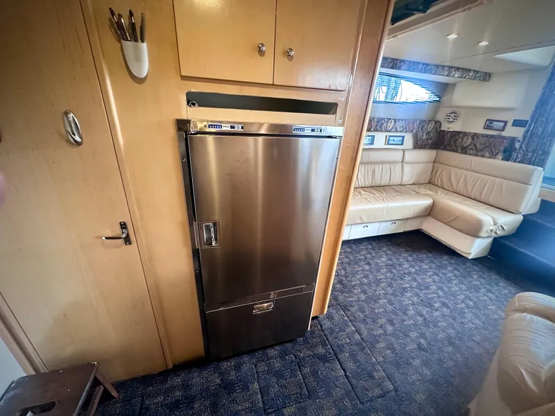 Slide: The Image of Interior of 1997 Carver 350 Mariner yacht with stainless steel fridge and beige seating. - 27
